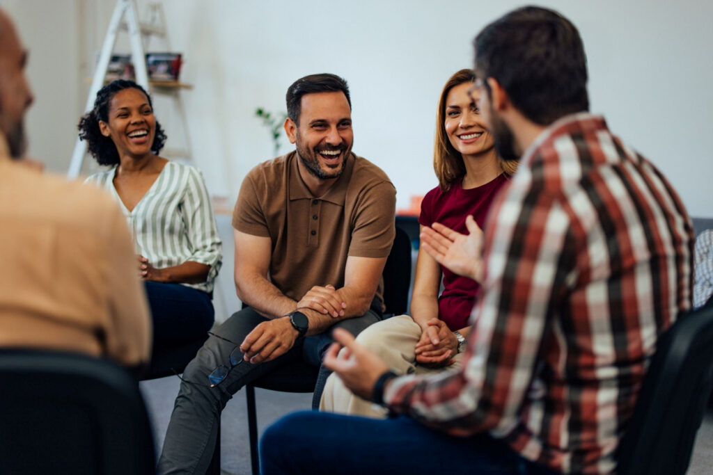 Group of people in an addiction support group discussing if addiction is genetic