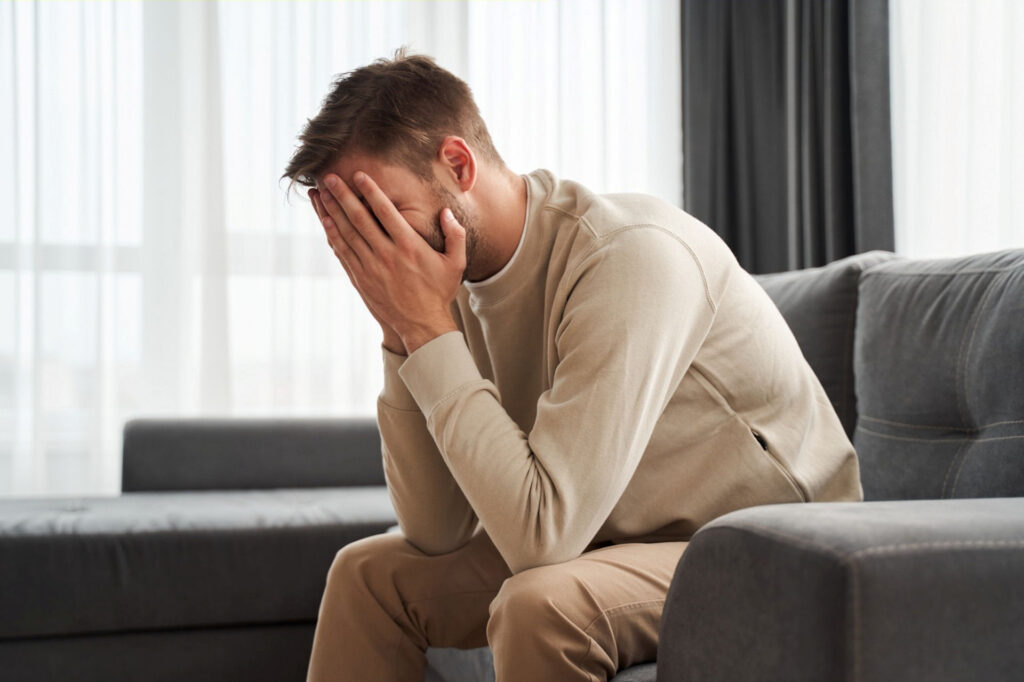 Man with PTSD leaning over and holding his head